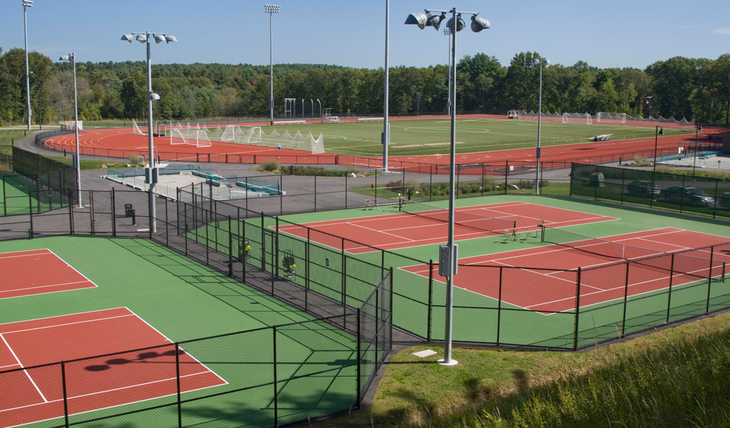 The Regis College tennis courts with the soccer field and surrounding track located in the background.