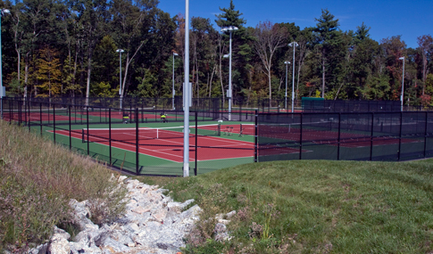 The Regis College tennis courts with riprap located in the foreground. 