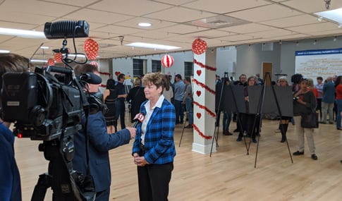 A television news crew interviews a woman at an Orlando Future Ready meeting.