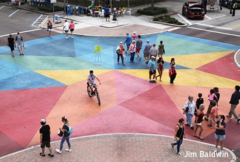 People cross an artistically painted intersection in St. Petersburg.