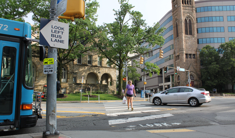 A woman crosses the street in the crosswalk