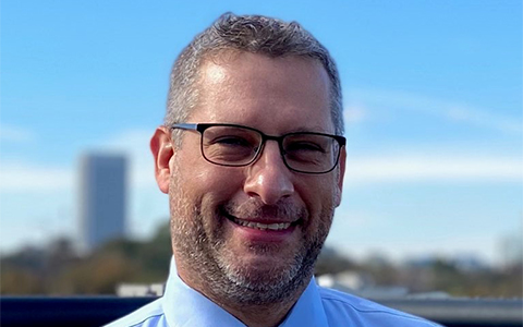 A photo of Jeffrey Goldberg wearing glasses, a tie and a dress shirt.