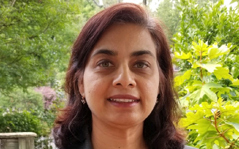 Sonali Soneji stands outside wearing a grey sports coat. 