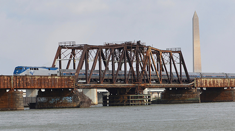  Amtrak Train Crossing over Long Bridge with the Washington Monument in the background.