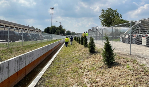 Crew members walk alongside the newly installed concrete channel at Burton Station.