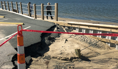 A section of a parking lot on the seashore edge that eroded from sand and water.