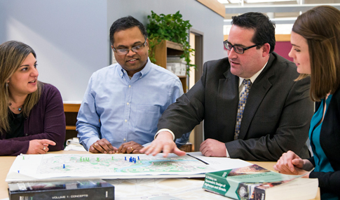 A group of VHB team members connect in the office.