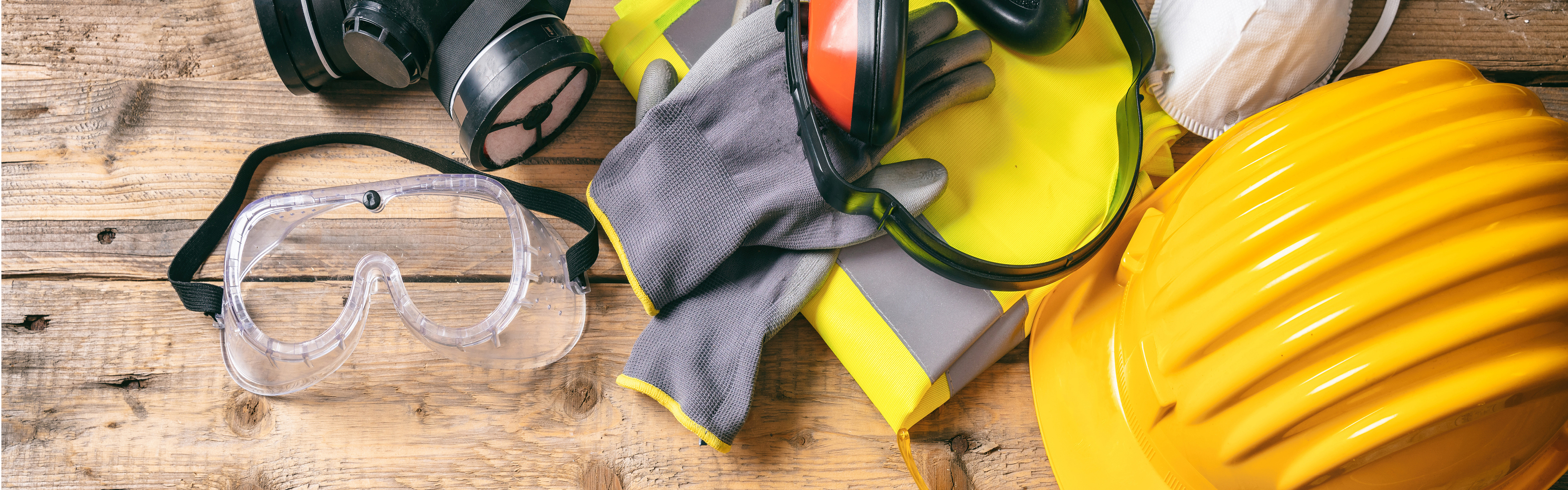 Construction and protective equipment laid out on a wooden table. 