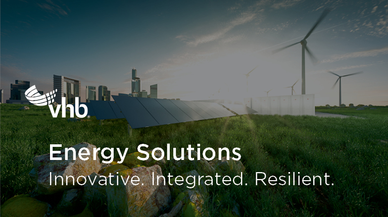 Solar panels and wind turbines with a city skyline in the background.