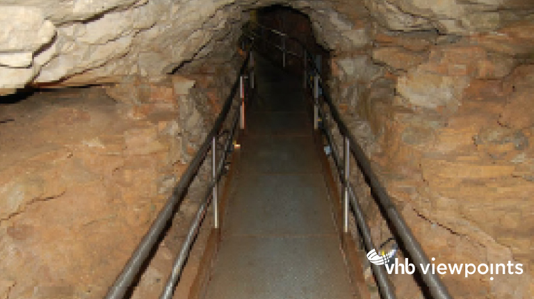 Metal hand rails flank a walking path inside a cave